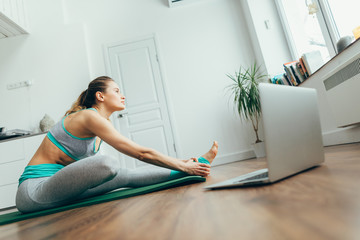 Young woman practicing head to knee yoga pose