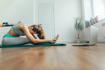 Young woman sitting in paschimottanasana yoga pose