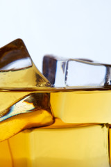 Close up of glass of whiskey with ice cubes (on the rocks). Copy space