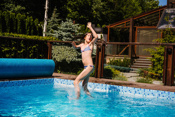 Naklejka premium Happy girl jumping in the the pool