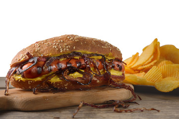 Hot dog with fried onions and chips. Isolated background