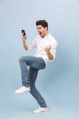 Full length portrait of a cheerful handsome young man