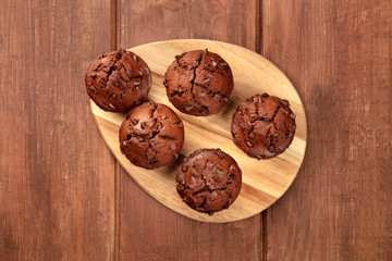 Chocolate chip muffins, shot from the top on a dark rustic wooden background with copy space