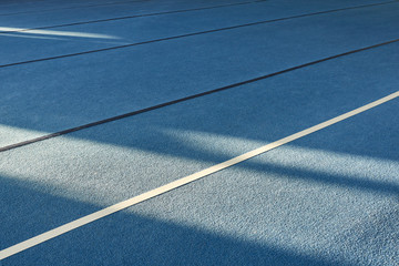 sun gym floor with diagonal color blocks. Background texture. Blue, black, white and yellow colors. Exercise concept, indoors sports, gymnastics. Bright and cheerful.