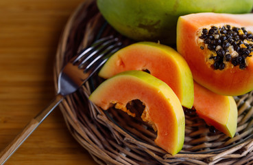Tasty, juicy, ripe fruit of mango on a wooden table-top in a plnteny bowl. Soft focus.
