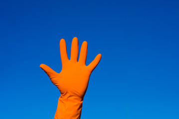 Hand in orazhevoy glove, a gesture against the blue sky.