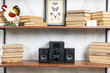 Compact music center in vintage residential loft interior on the shelf among books and accessories