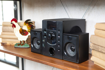 Compact music center in vintage residential loft interior on the shelf among books and accessories