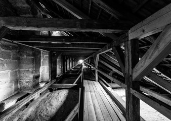 Fototapeta na wymiar Wooden structures (rafters and beams) of the attic of an old house. Black and white.
