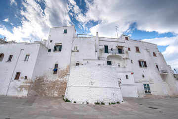 A street view of the old town - province of Brindisi, region of Apulia. Picturesque narrow with...