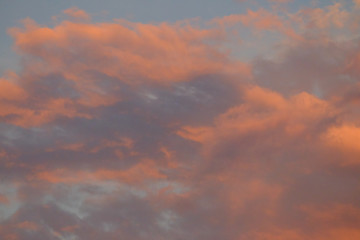 Orange clouds at dusk on grey sky for background texture 