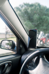 Closeup on handsfree car smartphone assistance, communication gps navigation system background....