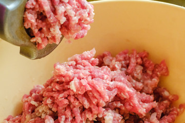 Close up meat grinder or mincing-machine with mincemeat in. Showing the forcemeat process.