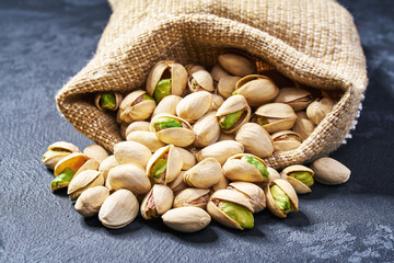 Pistachios are poured out of the bag on a black table,Close-up