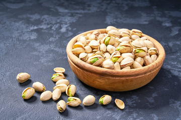 Pistachios in wooden bowl on black background  ,close-up