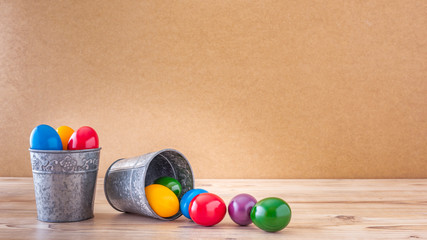 Zwei silberne Becher mit bunte Ostereier Vor einem Holz Hintergrund