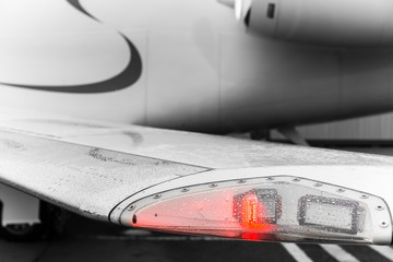 Closeup high detailed view on aircraft's red navigation light on wing