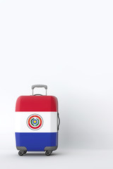 Travel suitcase with the flag of Paraguay. Holiday destination. 3D Render