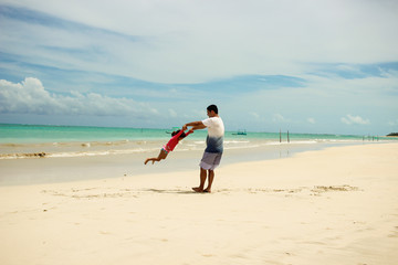 pai e filha se divertindo na praia