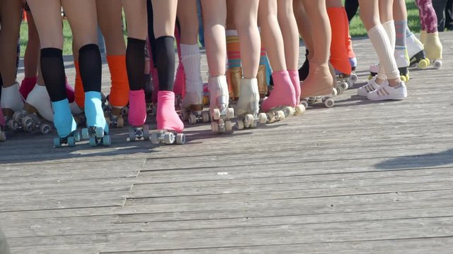 Young girls wearing roller-skates are gathered together and are waiting for their performance.