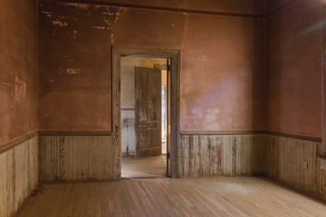 Looking through two doorways in a an old farmhouse with wainscoting