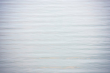 The blue water waves by wind and sunlight reflecting surface