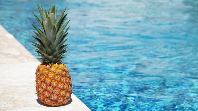 Pineapple near swimming pool at poolside. Travel concept card