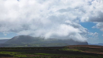 Clouds, fog and rain over a green volcanic mountain on Lanzarote.