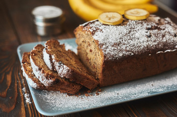 homemade sliced banana cake decorated with sugar powder and three banana