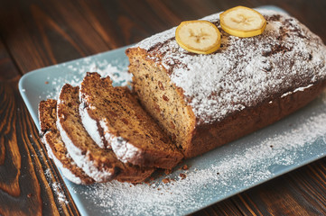 homemade sliced banana cake decorated with sugar powder and three banana