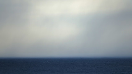 Obraz premium Dark clouds, fog and rain over the sea.