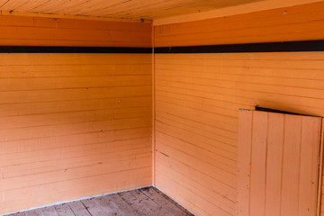 Orange wooden walls with black trim in old abandoned farm house