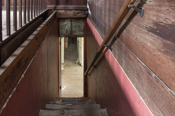 Staircase in old abandoned farmhouse with wood paneling