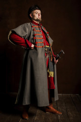 Portrait of a man in a medieval costume on a dark background. Clothes of the Polish gentry.