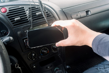 Closeup on hand holding smartphone for assistance, car communication gps navigation system background. Empty display ready for digital map assistant, modern electronic equipment technology device.