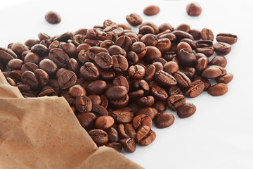 Coffee beans in paper bag on white background