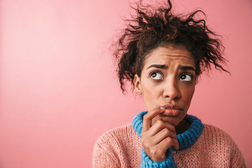 Sad beautiful young african woman posing isolated over pink wall background.