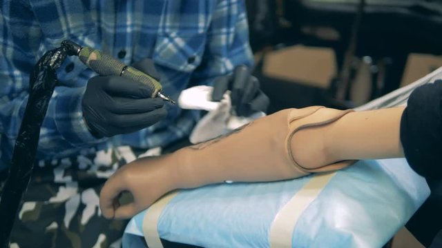 Tattoo is being made on a prosthetic arm