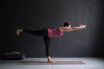 woman practicing yoga, doing Warrior III exercise, Virabhadrasana 3 pose