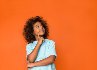 Little daydreamer. Girl holding finger on chin and looking away