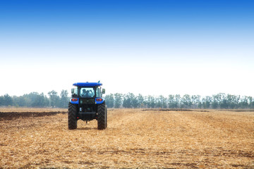 Modern tractor in the field during planting. The concept of agricultural industry.