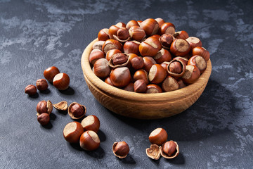 Hazelnut  in wooden bowl on black background  ,close-up