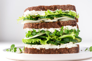 Sandwich with cucumber, lettuce, microgreen and ricotta. Diet, healthy, vegetarian breakfast.