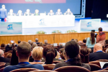 The audience in the auditorium. Conference or seminar. A stage with a podium and speakers....