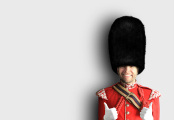 Young man in the costume of the Royal guards of Britain - obrazy, fototapety, plakaty