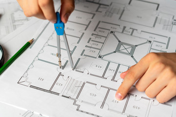 engineer sketching building project on a blueprint with a pencil b