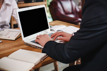 Close-up view of man's hands working on laptop