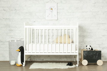  White wooden baby crib and toys in the room, Scandinavian inspired kids room interior - obrazy, fototapety, plakaty