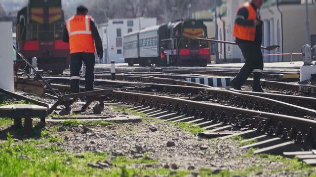 Train on the railroad and workers about the rail