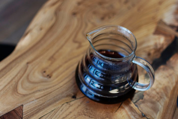 Bruch chemex coffeemaker cup of coffee. Black espresso, wooden texture background table